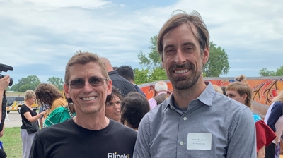 two people posing for a photo in a park